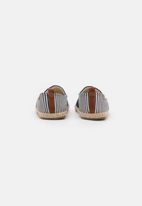 Gestreifte Stoff-Espadrilles mit braunen Lederdetails, runder Spitze und natürlicher Jutesohle. Die Rückansicht zeigt kontrastierende Fersenlaschen.
