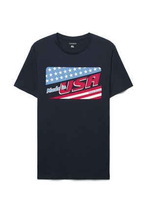Granatowy bawełniany t-shirt z grafiką przedstawiającą czerwono-biało-niebieską flagę amerykańską oraz napisem "Made in USA" w pogrubionych literach.
