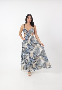Robe maxi à motif de feuilles crème et marine, avec un devant décolleté, des bretelles ajustables et une silhouette fluide. Tissu texturé.