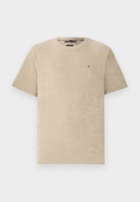 Beige puuvillatee pusa lühikeste varrukatega, ümar kaelus ja väike logo rinnal. Pehme tekstuur, lihtne disain.