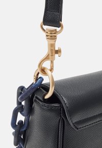 Borsa nera in pelle con texture, dotata di tracolla blu attaccata da una chiusura in oro incisa con la dicitura 'JOOP!'. 