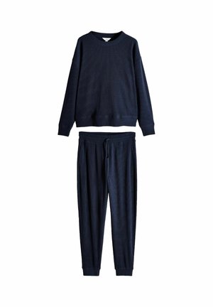 Dunkelblaue gerippte Strickoberteil mit langen Ärmeln und passende Jogginghosen mit Kordelzug flach auf weißem Hintergrund ausgelegt.