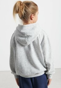 Felpa grigia con cappuccio, polsini a coste e vestibilità comoda. Realizzata in tessuto morbido e testurizzato, presenta un design semplice e informale.