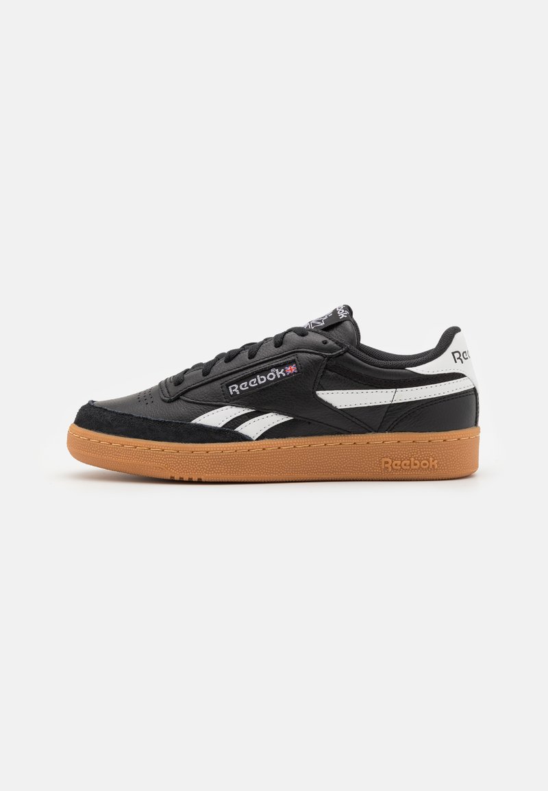 Čierne kožené tenisky s bielymi akcentmi a nubukovou špičkou. Obsahujú podrážku z gumy a šnurovací dizajn, označené logom Reebok.