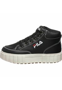 Mustat korkeat tennarit, jotka on valmistettu synteettisestä nahasta. Niissä on valkoiset ompeleet, pyöreät nauhat ja paksu valkoinen pohja, jossa on uurrettu muotoilu.