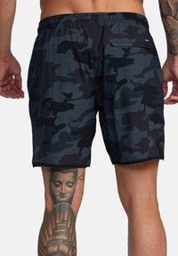 Herren-Badeshorts im dunklen Camouflage-Muster mit flexiblem Bund und einer Gesäßtasche. Der Stoff wirkt glatt, leicht und schnell trocknend.