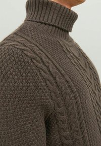 Ciemnobrązowy sweter z dzianiny w warkocze z wysokim żeberkowym kołnierzem, z teksturowymi wzorami i dopasowanym krojem.