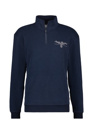 Marineblauwe fleece pullover met hoge kraag en half-ritssluiting. Kenmerkt zich door witte geborduurde branding op de borst, geribde manchetten en zoom.