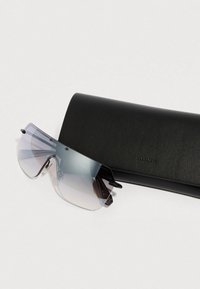 Óculos de sol com uma armação grande e plana, com lentes em degradê azul e preto, acompanhados de uma elegante capa de couro preta.