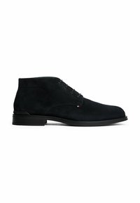 Stivale da uomo in suede nero alla caviglia con lacci, tacco basso e piccolo dettaglio cucito rosso, bianco e blu di lato.