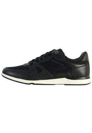 Chaussures de sport noires avec un mélange de matériaux lisses et texturés, dotées d'un laçage, d'une semelle blanche et de marquages subtils.