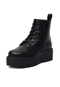 Czarne skórzane botki za kostkę z wysoką platformą, okrągłym noskiem i sznurowanym przodem. Posiadają przeszywane detale oraz pętelkę z tyłu.