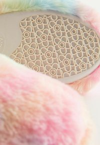 Fuzzy tofflor med flerfärgad pastellpäls. Sulan har ett blommönster i ljusbeige gummi, som ger ett strukturerat grepp.