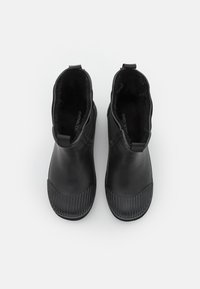Bottines en caoutchouc noires avec des semelles en caoutchouc texturées, un matériau supérieur lisse, des panneaux latéraux élastiques et des languettes pour un enfilage facile.