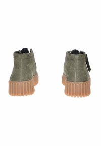 Stivali alla caviglia in pelle verde con finitura texture, dotati di suola marrone a coste e una linguetta sul retro per facilitarne l'uso.