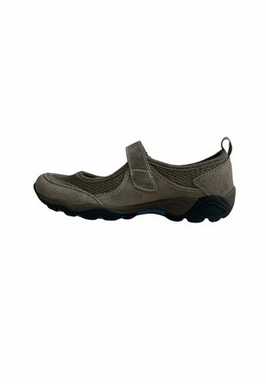 Zapatilla deportiva individual de estilo Mary Jane en color gris con tejido de malla y ante, correa de velcro y suela de goma negra vista de lado.