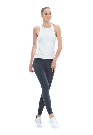 White athletic tank top with a high neckline, paired with dark gray leggings and white sneakers. The fabric appears smooth and fitted.