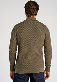 Olijfgroene gebreide trui met een gestructureerd ruitpatroon, lange mouwen en een geribde kraag en zoom. Zichtbare stiksel details.