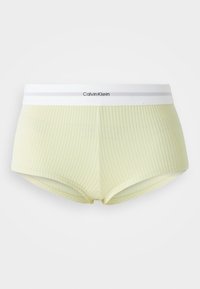 Light yellow ribbed boyshorts with a white Calvin Klein waistband. The waistband features a subtle gray stripe and logo.