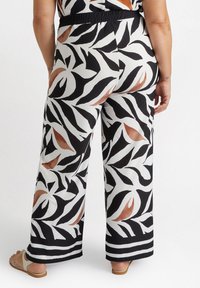 Wide-leg pants in a floral black, white, and brown pattern; made from a smooth fabric with an elastic waistband and contrasting stripe at the hem.