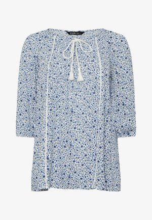 Bloes met bloemenmotief, voorzien van een witte achtergrond met blauwe en grijze patronen, een trekkoordhals met kwastjes, en driekwart mouwen.