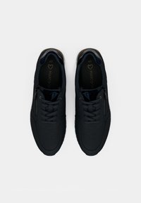Une paire de baskets noires avec des lacets et des fermetures éclair sur les côtés, taille 40, présentée vue du dessus sur un fond blanc uni.