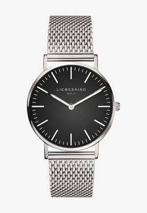 Montre-bracelet minimaliste avec cadran noir, index et aiguilles argentés, bracelet en maille argentée et inscription « Liebeskind Berlin » sur le cadran.