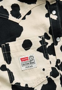 Fekete-fehér tehenes mintájú anyagú ing, mellzsebbel. A címkén a "Levi's Authentic Western Wear PIXAR" felirat olvasható.