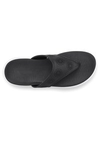 Mustat flip-flop sandaalit, joissa on teksturoitu pohja, reikäkappale, jossa on pyöreitä kuvioita, ja valkoinen ulkopohja kontrastiksi.