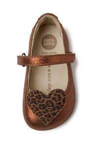 Zapato Mary Jane de cuero bronce con un acento en forma de corazón de estampado de leopardo. Presenta una correa a través del empeine y un diseño de punta redondeada.