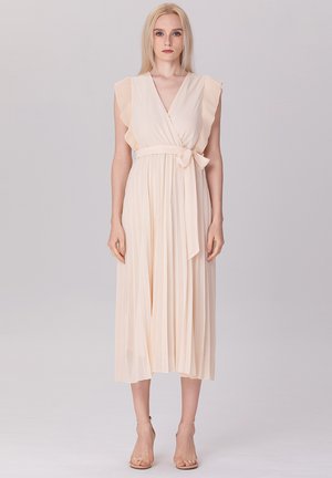 Robe plissée beige clair avec des manches volantes, un col en V et une ceinture nouée à la taille, présentant un design fluide et une texture douce.