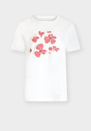 Fehér rövid ujjú póló korall rózsaszín virágmintával a mellrészen és apró márkanévtáblával a virágok alatt.