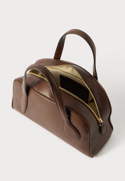 Borsa a mano in pelle marrone con forma arrotondata, manici doppi e una zip dorata. L'interno presenta una texture liscia e chiara con una tasca.