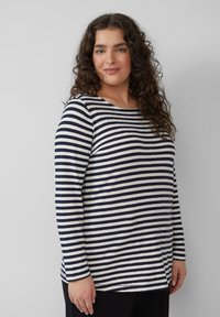 Top met lange mouwen met marineblauwe en witte horizontale strepen, een ronde hals en zachte stof. Het ontwerp heeft een losse pasvorm met een rechte zoom.