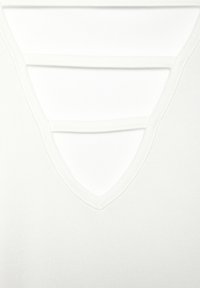 Top bianco lavorato a maglia con scollatura a V e tre strisce orizzontali intagliate. Texture liscia, stile minimalista e aspetto leggero.