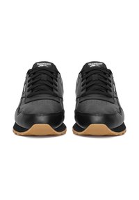 Mustad tennised, mille pealmine osa on sileast mehest, tekstuursete detailidega ning kummist tallaga kontrastse kummise tooniga. Omavad musti paelu ja logot.