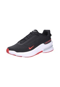 Zapatilla atlética negra con acentos rojos, que cuenta con una parte superior de malla con perforaciones, cuello acolchado y una entresuela blanca con amortiguación de aire visible.