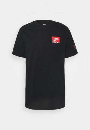 Zwart Nike T-shirt met korte mouwen, voorzien van een klein rood vierkant logo met de Nike swoosh op de linkerborst en een subtiele patch op de linkermouw.