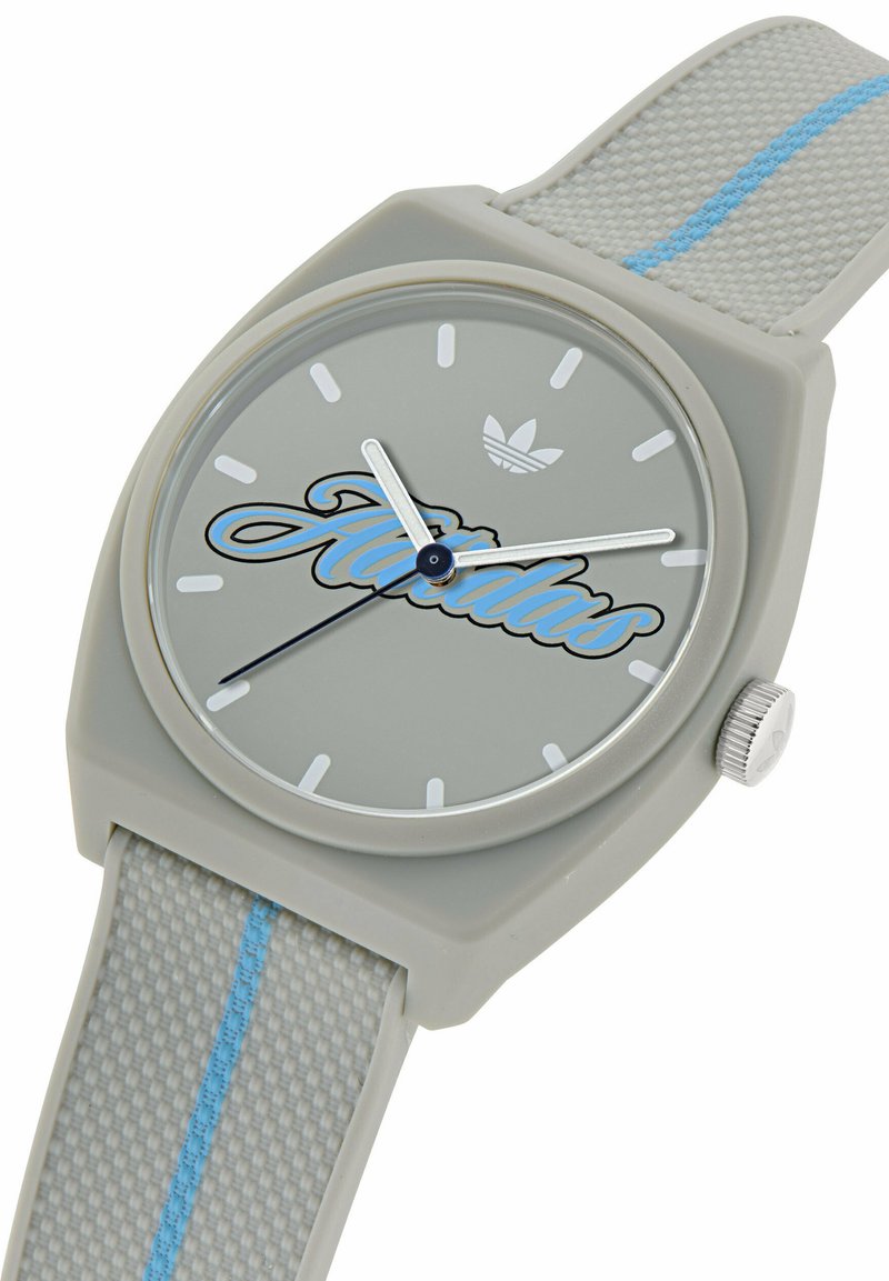 Orologio da polso Adidas grigio con logo script blu, indicatori delle ore bianchi e cinturino testurizzato con una striscia centrale blu.