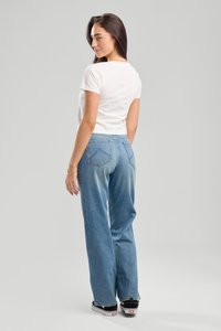 Kevyt valkoinen puuvillapaita yhdistettynä sinisiin haalistuneisiin farkkuihin. Paidassa on pyöreä kaula-aukko; farkuissa on kaksi takataskua ja suorat lahkeet.