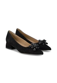 Pumps basse in suede nero con tacco basso e punta affusolata, caratterizzate da un accento decorativo floreale lucido nero sul davanti. Fodera interna liscia.