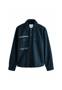 Camisa de botones verde oscuro con dos bolsillos frontales, detalles bordados y un cuello clásico. Fabricada con tejido texturizado.