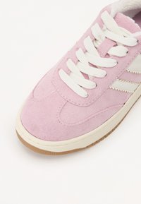 Sneaker in suede rosa con lacci bianchi, caratterizzata da tre strisce bianche sul lato e una suola in gomma color crema.