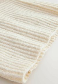 Pehmeast ribitud kudumisest valmistatud kanga off-white värv, mille pinnal on tekstuur ja veidi läike. Äärised on korralikult viimistletud.