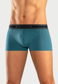 Pantaloni boxer turchesi con vita grigio scuro che presenta il logo "Bench." Tessuto liscio, design aderente e lunghezza corta delle gambe.
