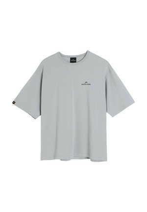 Jasnoszary, oversize T-shirt z krótkim rękawem, z małym czarnym logo "Coalition" na piersi i metką na lewym rękawie na białym tle.