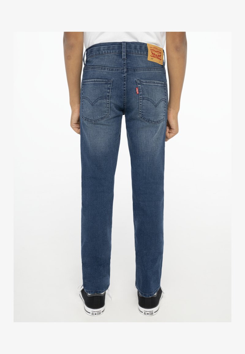 Dunkelblaue Jeans aus Denim mit geradem Bein, ausgestattet mit einem Lederpatch am hinteren Bund, zwei Gesäßtaschen und dezenter Ausbleichung.
