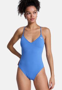 Μπλε ολόσωμο μαγιό με λεπτούς ρυθμιζόμενους ιμάντες, V-λαιμόκοψη, λεία υφή, και ένα μικρό λογότυπο στο αριστερό στήθος.