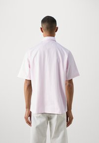 Krátky rukáv košele v svetložltej a bielej pruhovanej bavlne. Vyš-feature classic collar and relaxed fit with a curved hem.