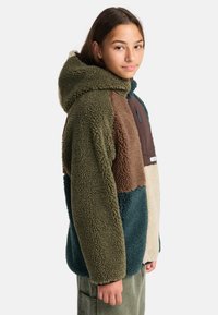 Giacca in pile con cappuccio, caratterizzata da pannelli multicolore in verde, marrone e beige; texture morbida con una tasca con zip sul davanti.